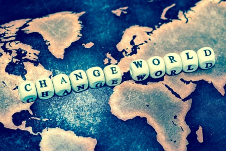Carte du monde avec dés disant "Change world" - Changer le monde, agir pour un monde meilleur