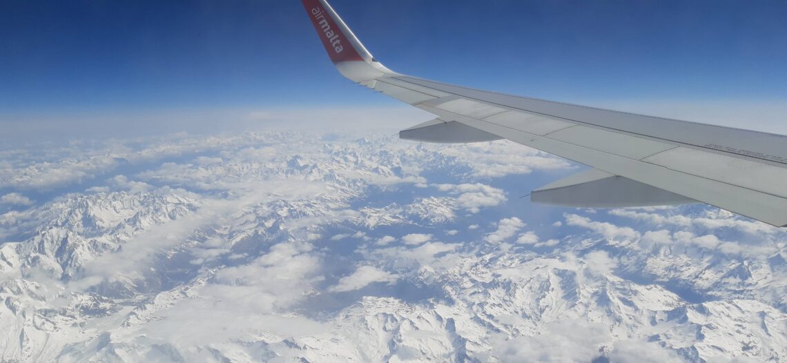 View from the plane overlooking the snowy Alps